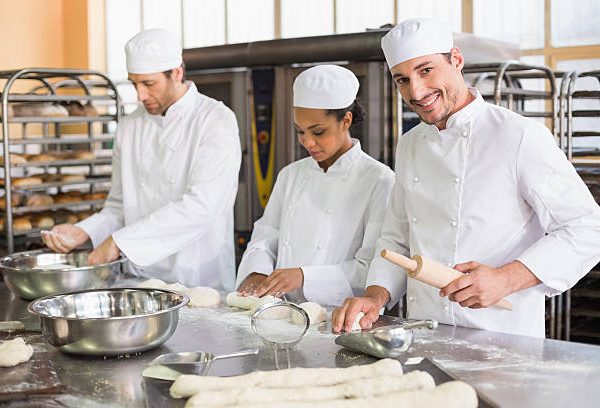 Équipe de boulangers préparant la pâte dans la cuisine de la boulangerie
